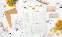 a bakery menu with flowers and cards on a wooden table